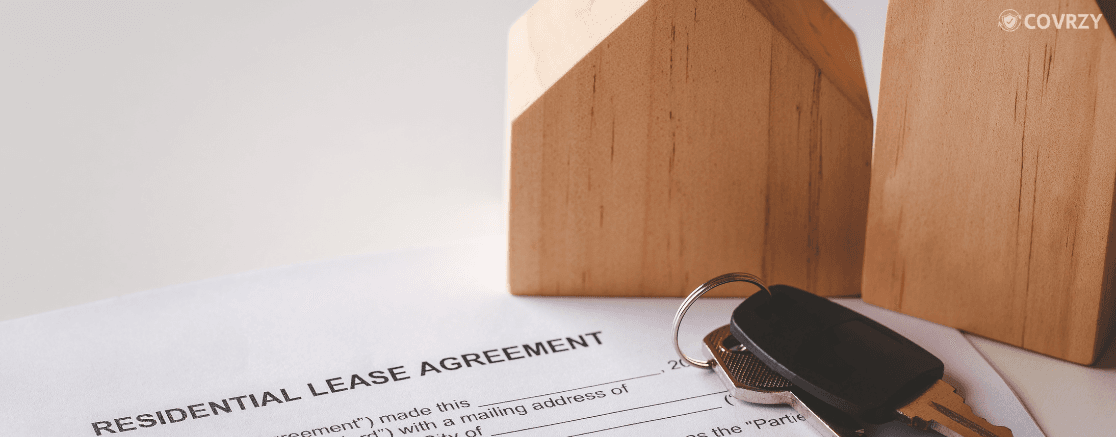 few miniature wooden houses with lease agreement papers lying under with some keys