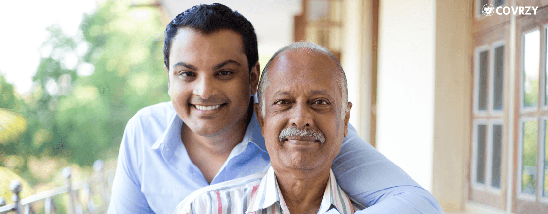 an Indian man with his left hand wrapped around an elderly Indian man
