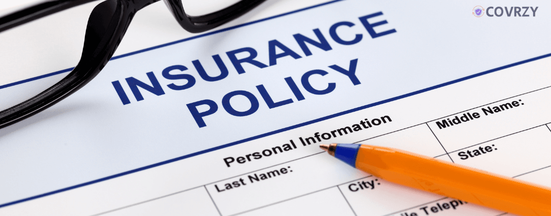 A specs lying on insurance policy paper with a yellow pen lying on it and Insurance Policy written on the paper