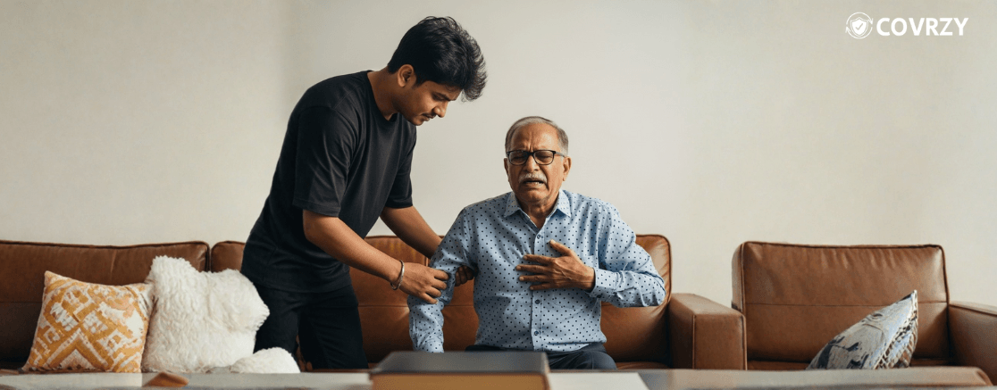 A young man is helping an old man to get up from a leather couch, while the old man is appearing in pain as his left hand is on his chest
